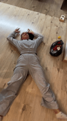 Woman laughs while lying spread-eagle on floor in Sofia