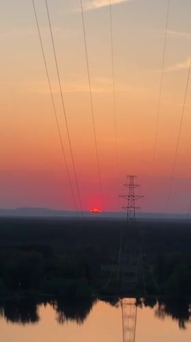 Sunset observed over rural Noviy, Russia with power infrastructure