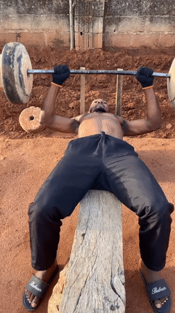 Man exercises with makeshift equipment in outdoor Bukuru workout