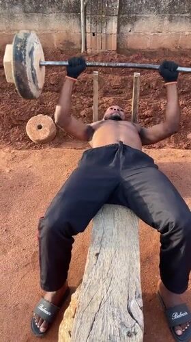 Man exercises with makeshift equipment in outdoor Bukuru workout