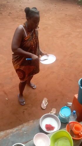 Woman gets hair styled in Nigerian residential area