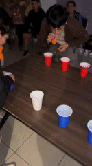 Late night gathering observed around table with plastic cups