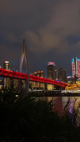 Chongqing's illuminated skyline and red bridge captured at night