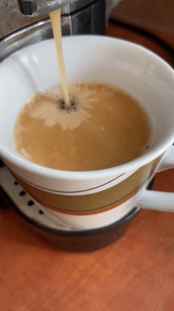 Coffee machine fills striped mug in Dronten morning routine