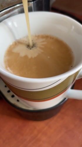 Coffee machine fills striped mug in Dronten morning routine
