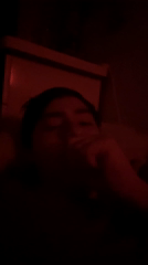 Person coughs in red-lit room with salt lamp