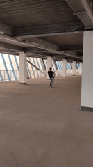 BMX riders practice tricks in indoor concrete venue