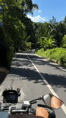 Motorcyclist rides through green countryside in Kediri, Indonesia