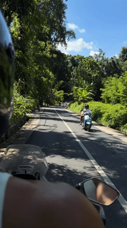 Motorcyclist rides through green countryside in Kediri, Indonesia