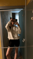 Woman takes mirror selfies while adjusting hairstyle in Khimki