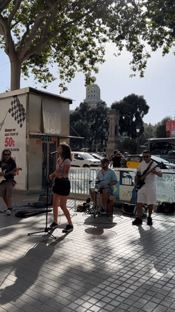 Street music and foot traffic fill central Barcelona on a sunny afternoon