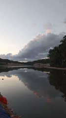 Still water reflects open sky near Serubeba, Indonesia