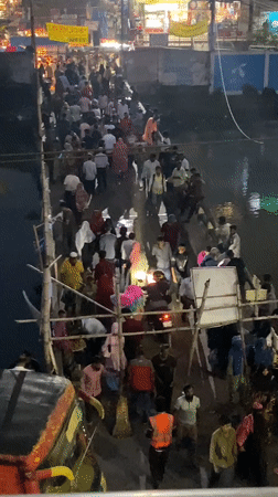 Crowds cross makeshift bamboo bridge over Dhaka river
