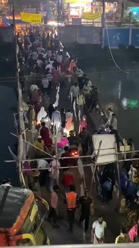 Crowds cross makeshift bamboo bridge over Dhaka river
