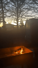Evening backyard fire pit burns in residential Tbilisi