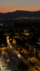 Konya at dusk, city lights coming on beneath a mountain horizon