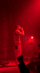 Male artist performs concert at London venue under colored lights