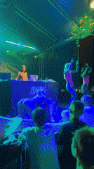 Night concert: DJ set, dancers, colorful stage lights, festive crowd
