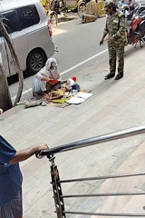 Woman tends to baby on Dhaka sidewalk