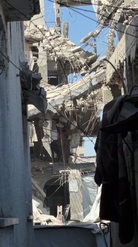 Inside a collapsed Gaza building, two people work through rubble