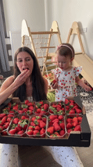 Mother, child enjoy fresh strawberries at home in Wisła