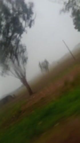 Vehicle passenger records rural landscape with ruins in Vom, Nigeria
