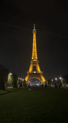 Evening visitors gather at illuminated Eiffel Tower in Paris