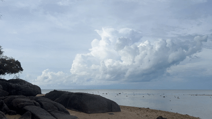 Dramatic clouds gather over calm Thai coastline