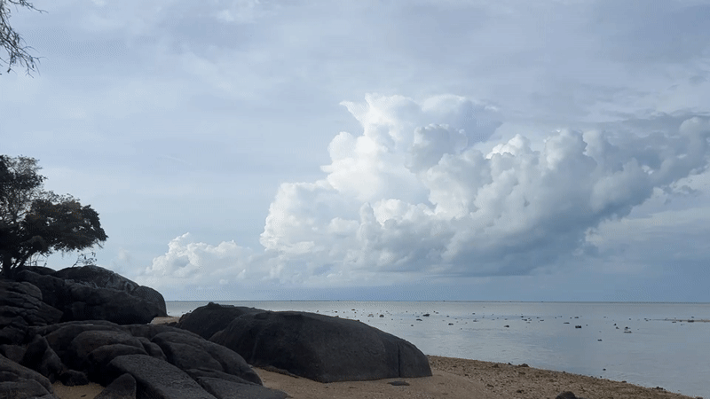 Dramatic clouds gather over calm Thai coastline