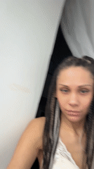 Woman peers from behind curtain in Rusanovo, Russia