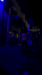 Late-night dancing and a curious cat under blue lights in San Juan