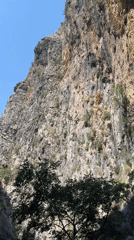 Canyon walls, flowing water, and a red motorcycle in Alanya