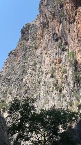 Canyon walls, flowing water, and a red motorcycle in Alanya