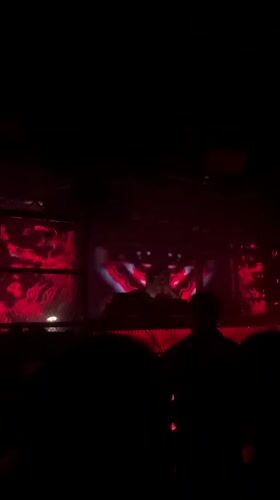 Red-lit Barcelona nightclub, DJ set in full swing