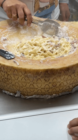 Cheese wheel pasta being served at a Primorsko street food stall