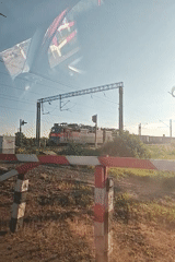 Freight train passes through Kambarka, Russia behind railway barrier