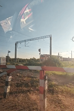 Freight train passes through Kambarka, Russia behind railway barrier
