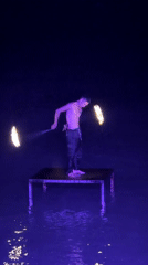 Fire dancer spins twin torches over water in Baan Chaweng