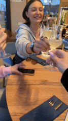 Group shares drinks at restaurant table with floral centerpiece