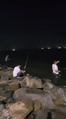 Nighttime waterfront gathering documented in Lhokseumawe, Indonesia