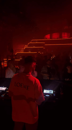 DJ behind the decks at a red-lit Patong nightclub