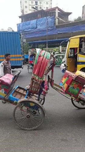Morning street life in Dhaka: rickshaws, vendors, and dense traffic