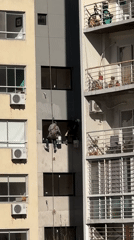 Building maintenance workers rappel down Buenos Aires facade