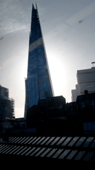 Morning sunlight backlights London's Shard through urban rooftops