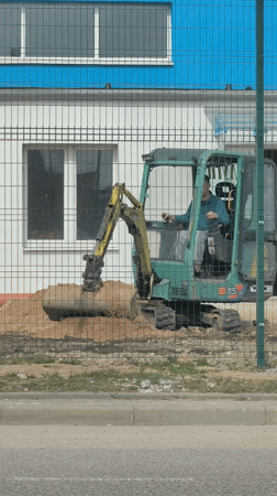 Excavator moves dirt at construction site in Hrodna