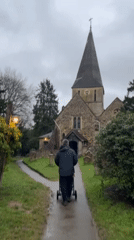 Father walks baby stroller to church in Guildford