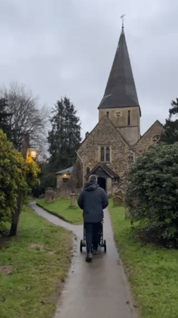 Father walks baby stroller to church in Guildford