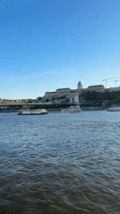 Tourist documents sunset river cruise through Budapest landmarks