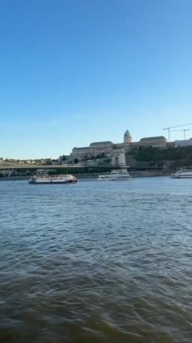 Tourist documents sunset river cruise through Budapest landmarks