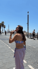 Woman enjoys morning stroll along Tel Aviv beachfront boardwalk